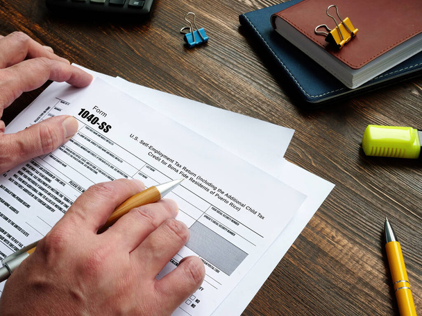 Conceito de negócio sobre o Formulário 1040-SS U.S. Self-Employment Tax Return (Incluindo o Crédito Fiscal Infantil Adicional para Residentes Bona Fide de Porto Rico) com inscrição no pedaço de papel - Foto, Imagem