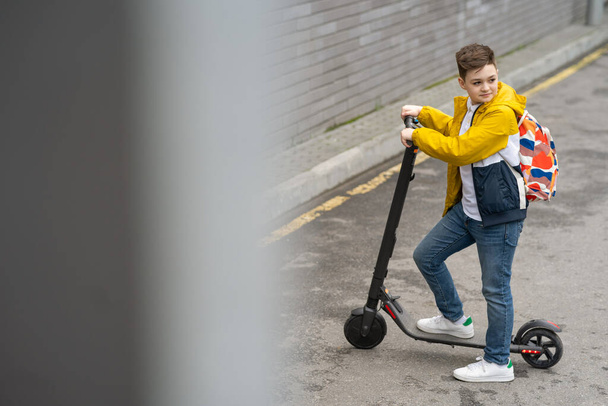 Adolescente moderno en scooter eléctrico. Concepto de transporte ecológico  - Foto, Imagen