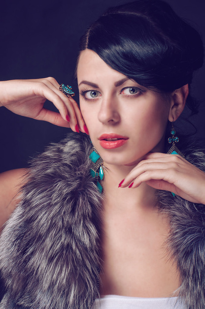 Young woman in a fur coat in  earrings - Foto, Imagen