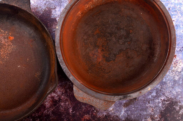 Roestige metalen pannen op een rustieke achtergrond. Renovatie van gietijzeren pan. Oude roestige ronde gietijzeren koekenpan. zicht van bovenaf - Foto, afbeelding