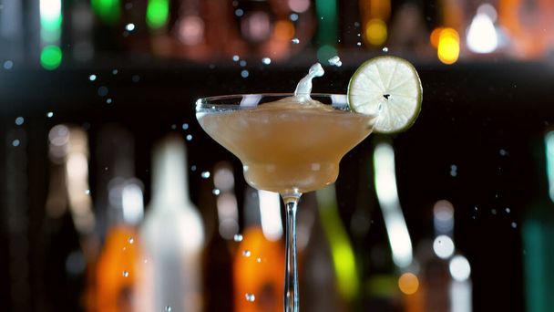 Freeze motion of splashing cocktail drink in bar. Free space for text - 写真・画像