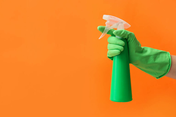 Рука в гумовій рукавичці з розпилювачем води на кольоровому фоні
 - Фото, зображення