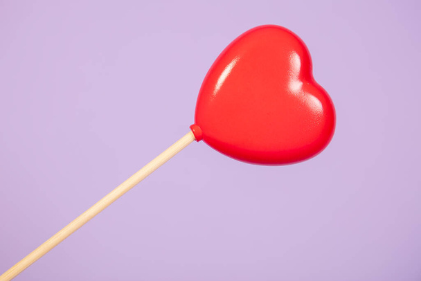 heart on a stick, isolated on purple background - Foto, imagen