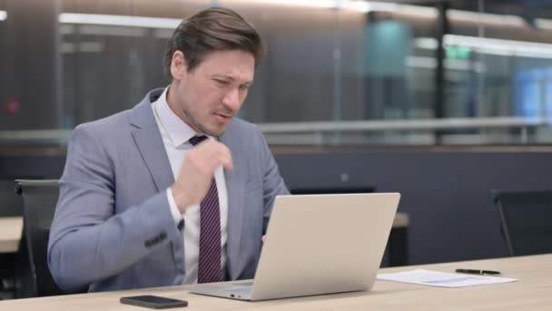Geschäftsmann mittleren Alters mit Laptop hat Nackenschmerzen im Büro  - Filmmaterial, Video