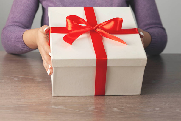 woman hand holding gift box on the desk - Foto, imagen