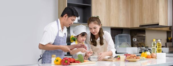 Asyalı aileler, modern evdeki mutfak odasında ev yapımı salata yemeklerinden hoşlanırlar. Aile içinde aktiviteler oluşturun. Merkezdeki çocuklara odaklanın, Kopyalama alanı olan Banner. - Fotoğraf, Görsel