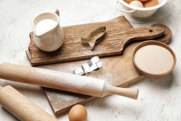 Ingredients for cookies and rolling pins on light background - Foto, imagen