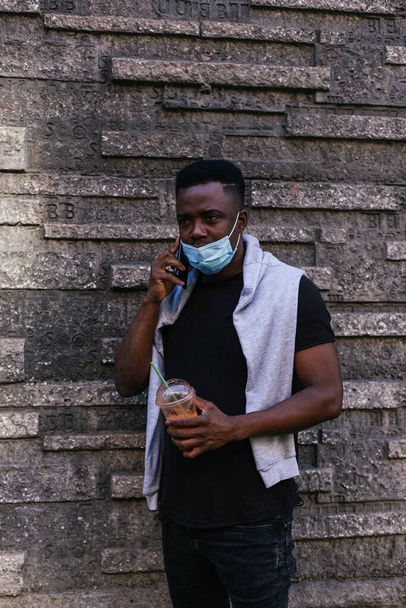 Afrikai amerikai kezében egy smoothie miközben beszél a telefonon - Fotó, kép