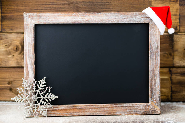 Christmas chalkboard with decoration. Santa hat, stars,  Wooden Background. Vintage Rustic Style. - Фото, зображення