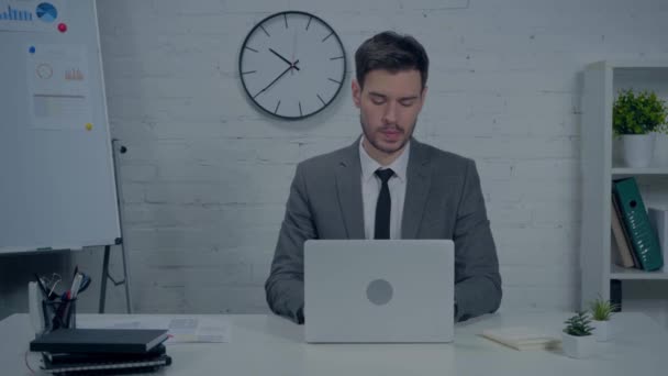 ориентированный бизнесмен в костюме с помощью ноутбука в офисе - Кадры, видео
