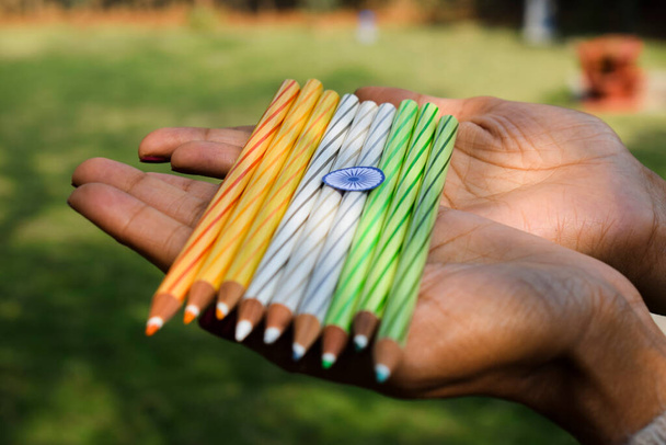 Indian flag tricolor tiranga saffron, white and green embroidery threads. Female palms holding colour pencils as concept for Indian republic day celebration depicting concept of freedom - Photo, Image