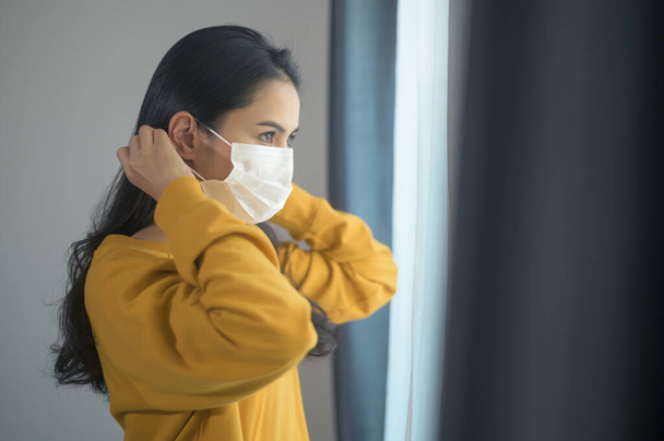 A young beautiful woman wearing a protective facial mask getting ready to go outside, Healthcare and covid-19 concep - Φωτογραφία, εικόνα