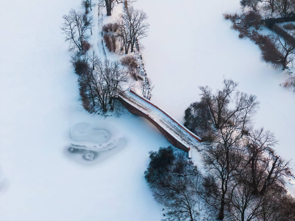 Winter panorama. Frozen trees, bushes and meadows.Winter scene - Old bridge in winter snowy park. Aerial view. - Photo, Image