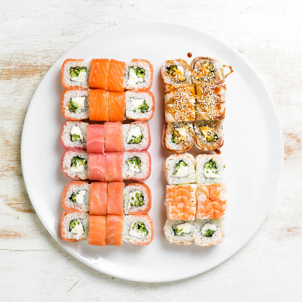 Asian cuisine. Large set of sushi rolls on a plate. Top view. On a white background. - Foto, Imagem
