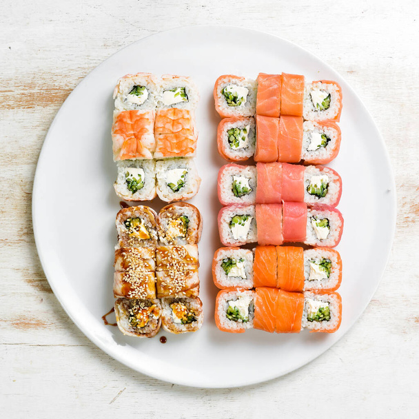 Asian cuisine. Large set of sushi rolls on a plate. Top view. On a white background. - Foto, Imagem