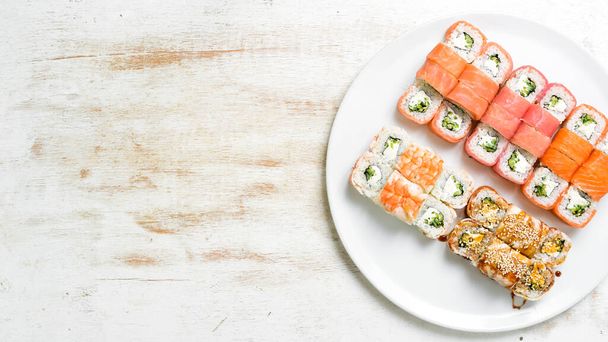 Asian cuisine. Large set of sushi rolls on a plate. Top view. On a white background. - Fotografie, Obrázek