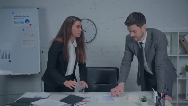 Frustrierte Geschäftsfrau wirft Diagramme auf Schreibtisch und spricht mit Kollegin  - Filmmaterial, Video