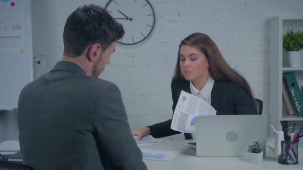 disgustada empresaria sosteniendo gráficos y mostrando un gesto de despedida al gerente - Metraje, vídeo