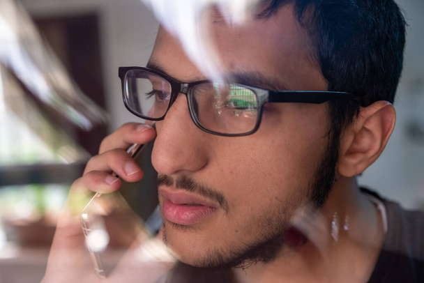 Facet rozmawiający przez telefon patrząc przez okno - Zdjęcie, obraz