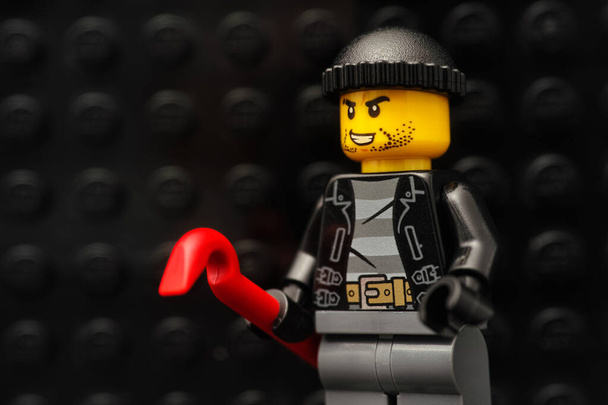 Tambov, Russian Federation - January 13, 2021 Lego robber minifigure with a red crowbar. - Zdjęcie, obraz