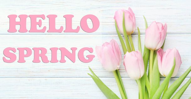 Bouquet of tulips with text Hello Spring on a white wooden table - Photo, image