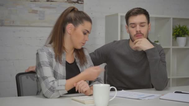mujer usando calculadora mientras discute cartas con el hombre - Metraje, vídeo