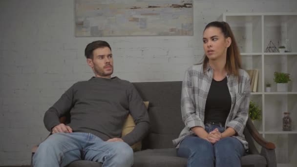 mujer disgustada peleando con el hombre mientras se sienta en el sofá apretó las manos - Metraje, vídeo