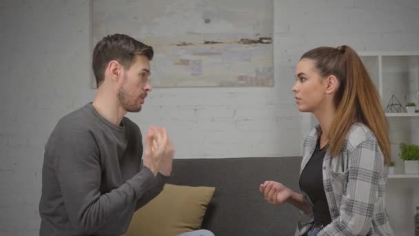 Unzufriedene Frau streitet mit unzufriedenem Freund im Wohnzimmer - Filmmaterial, Video