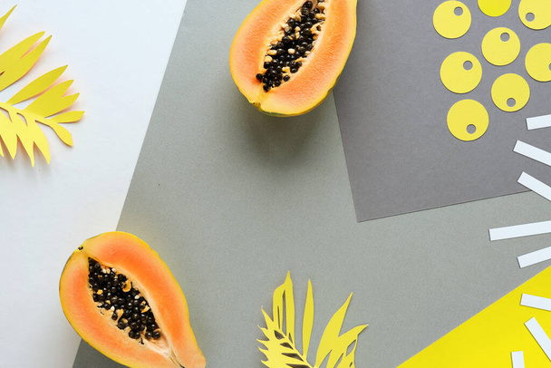 Background with papaya, exotic fruit and leaves. Illuminating Yellow and Ultimate Gray, colors of the year 2021. Layered flat lay with paper circles, palm leaf silhouettes. - Fotó, kép