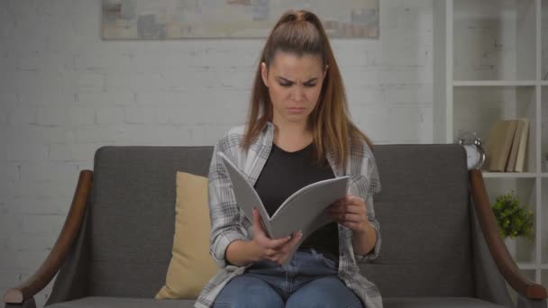 mujer disgustada sosteniendo carpeta con documentos en casa - Metraje, vídeo