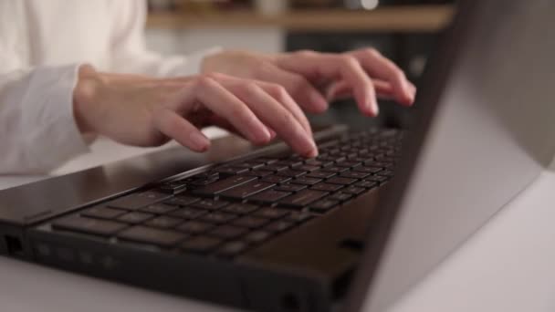 Lavoro a distanza. La donna prende appunti in notebook e stampa a tastiera di computer portatile. Concetto di istruzione a distanza e e-learning - Filmati, video