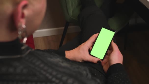 Close up uomo omosessuale con una manicure in possesso di cromakey schermo verde smartphone guardare contenuti, scorrimento scorrevole, videochiamata chat. Gadgets concetto di persone. - Filmati, video