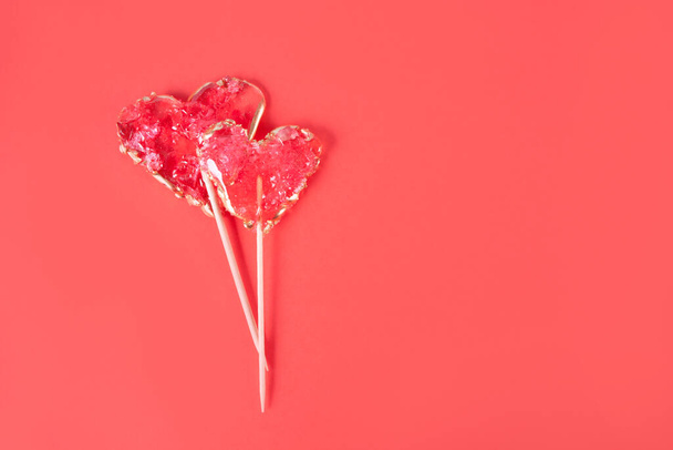 Heart-shaped lollipops candy on red background. Top view. Copy space. - Foto, Bild