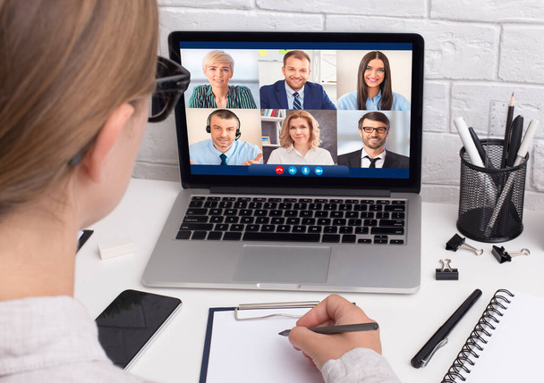 Empresaria teniendo reunión virtual a través de videollamada sentada en el lugar de trabajo - Foto, imagen