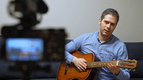 Hombre con guitarra española delante de la videocámara. - Foto, Imagen