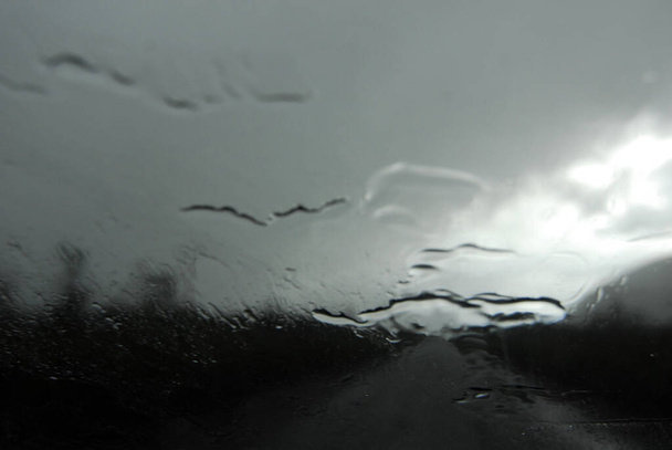 Pencerenin camına yağmur ve yağmur damlaları düşer. - Fotoğraf, Görsel