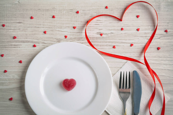 valentines day concept. table setting with heart shaped cutlery on wooden background - 写真・画像