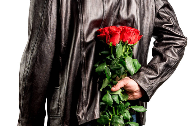 Человек с букетом красных роз за спиной. Элегантный мужчина с красными цветами розы в руке. Романтические и Валентинов день праздник концепции - Фото, изображение