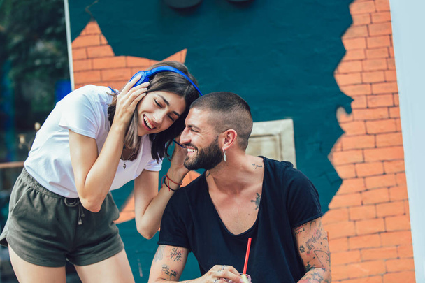Счастливая влюбленная пара в наушниках с музыкой в кафе - Фото, изображение