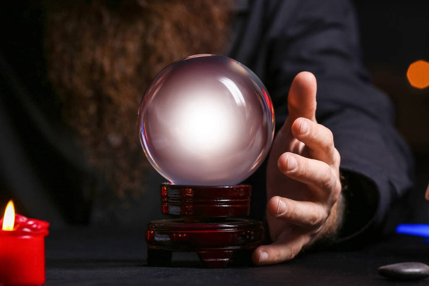 Male fortune teller with crystal ball at table, closeup - Photo, Image