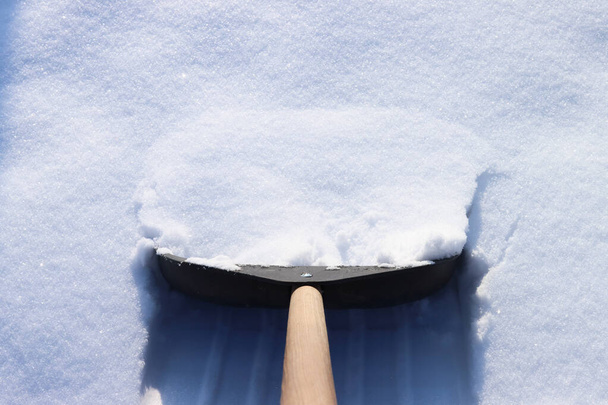 Schep verwijdert sneeuw na sneeuwval in de winter - Foto, afbeelding
