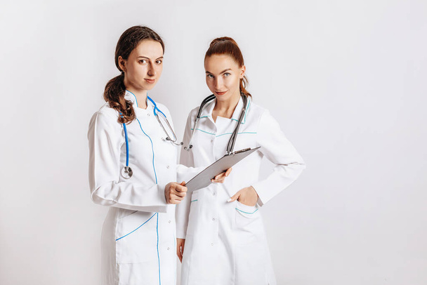 Medical documents. Two doctors with stethoscope at hospital. Nurse hold patient medical chart. Information data. Therapist in uniform. Medical history prescription. Woman work at clinic. - Valokuva, kuva