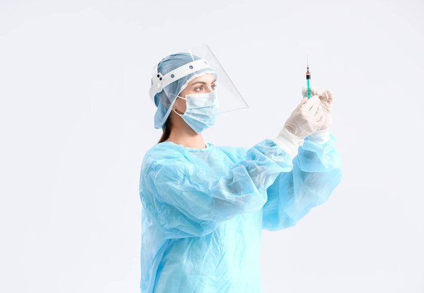 Portrait of female doctor with syringe on light background - Φωτογραφία, εικόνα