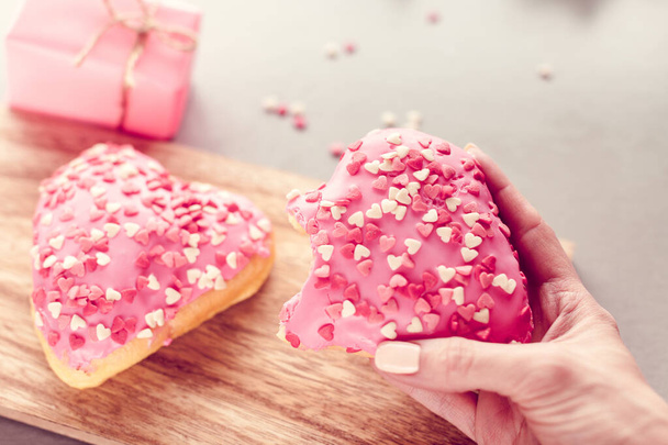 dulce donut en forma de corazón en una mano - Foto, Imagen