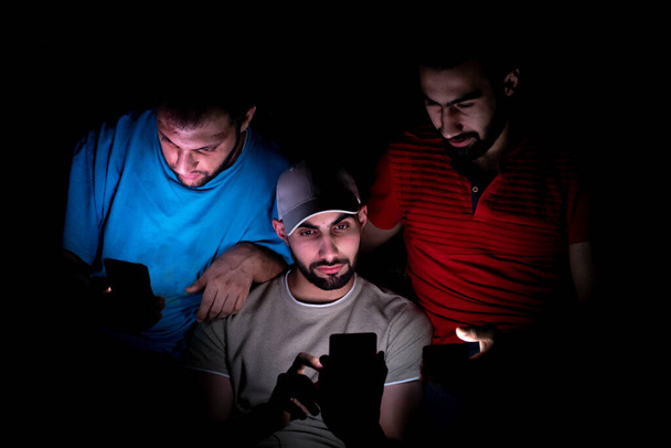 portrait of middle eastern guys setting together in a dark room - Foto, immagini