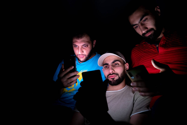 Porträt nahöstlicher Typen, die in einem dunklen Raum zusammenkommen - Foto, Bild