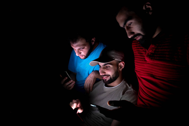 retrato de chicos de oriente medio montándose juntos en una habitación oscura - Foto, Imagen