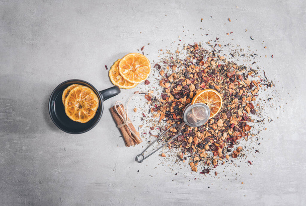 Fruit tea with cinnamon and dried orange in a cup - teacup isolated on gray. Top view, overhead - Foto, Imagem