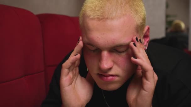 Sluit maar af. Portret van een knappe, vermoeide jonge homoseksuele man met hoofdpijn. Man met manicure wrijven tempels, met stress. - Video