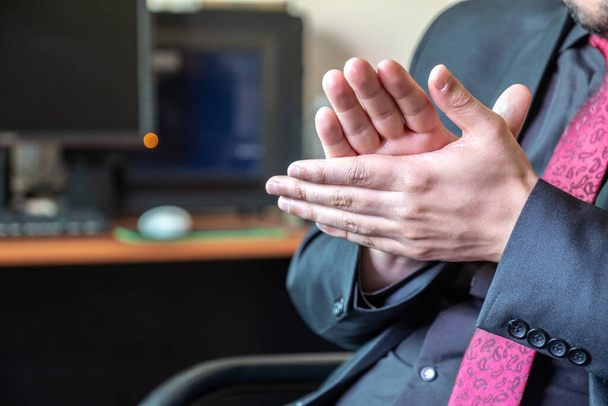 Μουσουλμάνος επιχειρηματίας που εργάζεται στο γραφείο του και καθαρίζει τα χέρια του - Φωτογραφία, εικόνα
